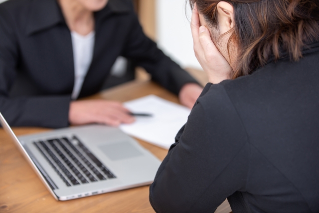 不動産相談で悩む女性と相談員の対面シーン