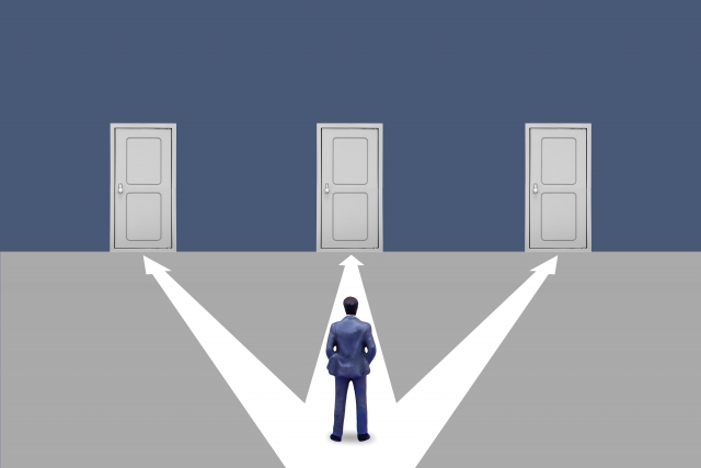 3つのドアの前に立つビジネスマンが選択肢を検討するコンセプトイメージ