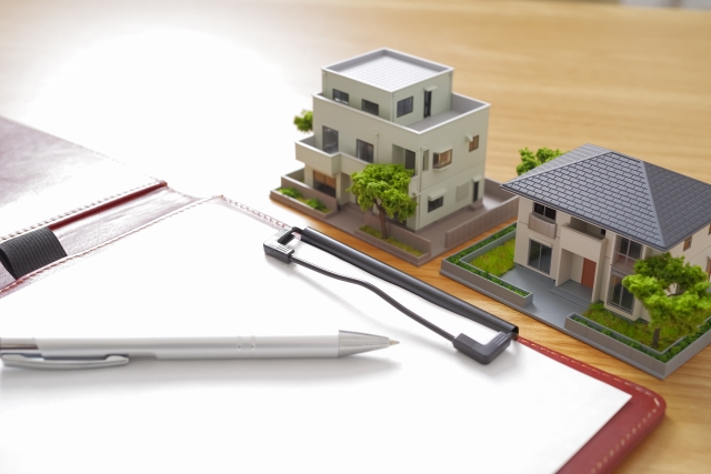 マンションと戸建ての住宅模型が並んだ不動産比較検討のイメージ