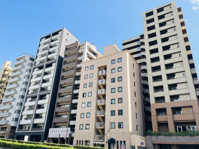 青空の下に並ぶ複数棟の高層マンション群の外観