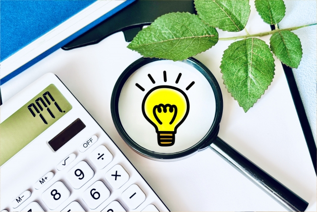 電卓と虫眼鏡の中に描かれた電球マークによる不動産の知恵・ヒントのイメージ